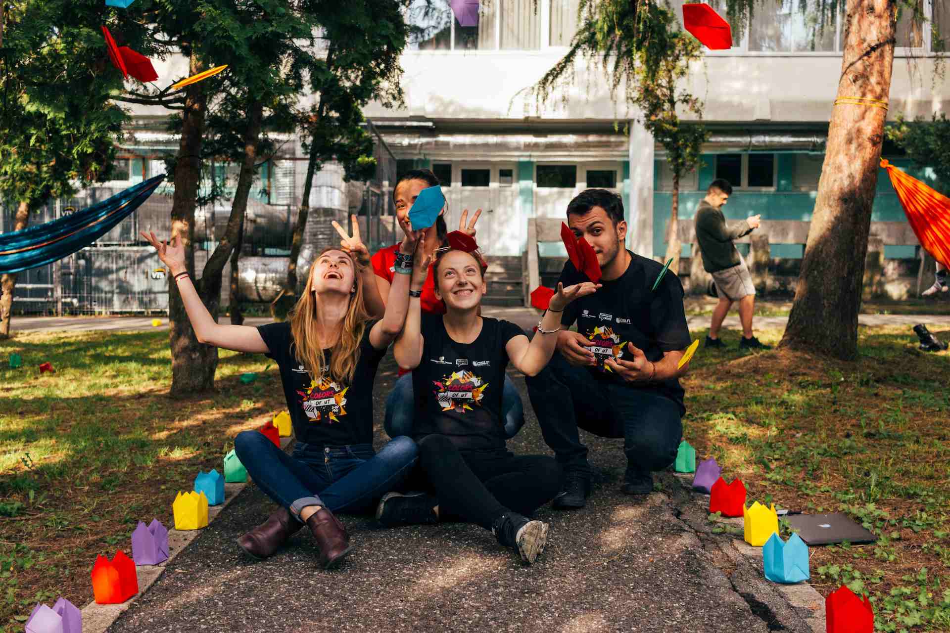 Image displaying a group of people happily looking at the camera and throwing confetti into the air.